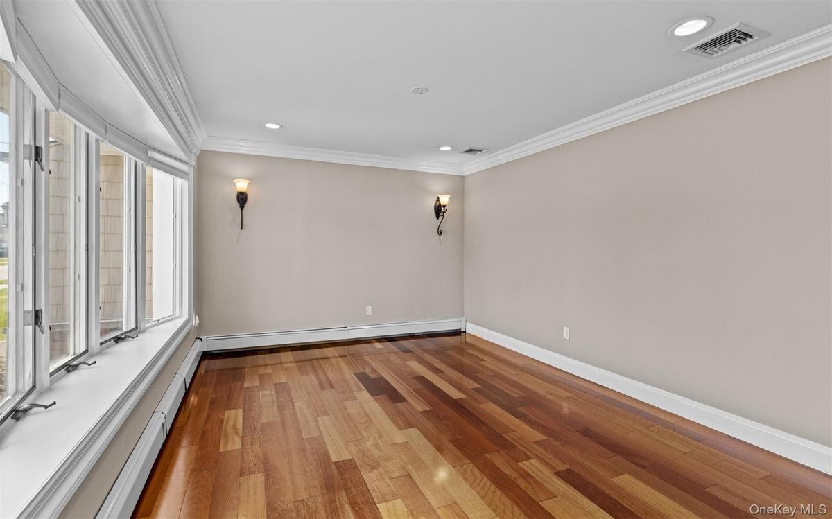 Cherry wood finish flooring, base and crown moldings, large bay window, recessed lighting