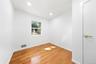 Hardwood flooring, recessed lighting, white interior walls, white trim, and a window with exterior scenery