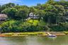 Waterfront property featuring a multi-story residence with expansive deck, a natural shoreline, and a private dock.