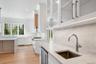 Butlers pantry is outfitted with sink and beverage cooler and links the kitchen to the dining room