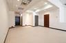 Recessed lighting, drop ceiling, light-colored carpeting, multiple doors, and a fire exit