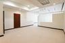 Glass block partition, recessed lighting, track lighting, light-toned carpeting, and a dark wood-finish door