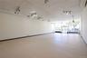 Expansive open-concept room with light-colored flooring, white walls, and track lighting fixtures