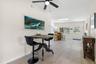 A flexible casual dining area features neutral tones, 2025 luxury vinyl plank flooring, and a ceiling fan, with an open layout that easily accommodate