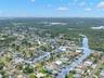 An aerial view showcases Baywood Village’s network of saltwater canals and the home’s close-to-the-water setting, with direct Gulf access from the nei
