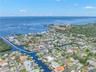 A sweeping aerial view puts the waterfront setting in perspective, showing Baywood Village’s canal system winding toward the open Gulf of Mexico — a s