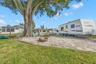 The extended side yard adds exceptional flexibility with room for RV, boat, or trailer parking, while a gravel gathering area with a fire pit sits ben