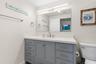 The remodeled primary bath (2025) features a wide gray vanity with abundant drawer storage, a sleek white countertop, oversized mirror, and contempora