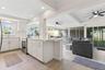 The updated kitchen (2025) opens directly to the living area and features crisp white cabinetry, stainless steel appliances, abundant counter space, r