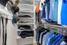 A well-organized walk-in closet in the primary suite offers built-in shelving, double hanging space, and plenty of room to keep clothing and accessori