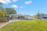 A spacious screened lanai extends across the rear of the home, offering plenty of covered space for relaxing, dining, and enjoying the backyard.