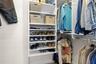 A well-organized walk-in closet in the primary suite offers built-in shelving, double hanging space, and plenty of room to keep clothing and accessori