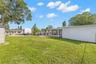 The oversized 11,800-square-foot (.27-acre) property continues into a broad backyard with generous lawn space, fencing for added separation, and plent