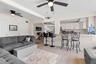 The spacious living area features dual ceiling fans, a soft neutral color palette, and 2025 luxury vinyl plank flooring, with an open connection to th