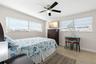 The third bedroom features two walls of windows, a ceiling fan, neutral tones, and luxury vinyl plank flooring (2025), with enough space for both slee