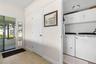 A dedicated laundry room keeps everyday chores tucked neatly away, with a full-size washer and dryer, overhead cabinetry for storage, and convenient a