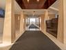 Lobby with polished floor tile, integrated wall sconces, wood-finish ceiling accent, and a built-in reception desk