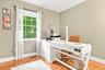 Hardwood flooring, neutral wall paint, white trim, and a multi-pane window