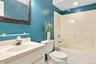 Integrated vanity with a single basin sink, wall-mounted mirror, and tub/shower combination