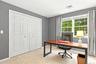 Double-panel closet doors, two large windows, wall-to-wall carpeting, and neutral wall paint