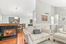 Hardwood flooring, a built-in fireplace with a stone and modern lighting