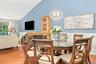 Vaulted ceiling, chair rail molding, wood-flooring, built-in cabinetry, and a decorative pendant light fixture