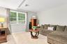 Recessed lighting illuminates the space, featuring light-colored wall paint and light-toned carpeting