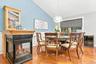 Vaulted ceiling, hardwood flooring, built-in display cabinet, three-sided fireplace, and pendant lighting