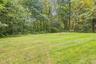 Expansive lawn area bordered by mature trees