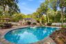 Poolside bar has granite top with a sink and refrigerator