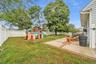 Outdoor patio with brick accents and a fenced yard