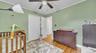 Wood-finish flooring, ceiling fan, white bi-fold closet doors, and white trim