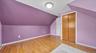 Hardwood flooring, painted walls, built-in closet with bi-fold doors, flush mount ceiling light fixture, and a white door with a round knob