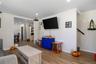 Wood-finish flooring throughout, recessed ceiling lighting, crown molding, and an open entryway to an additional room