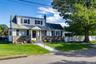 Two-story residence featuring stone and siding exterior, a gabled entry, bay window, and a paved walkway