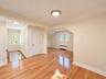 Hardwood flooring, recessed lighting, neutral wall tones, white trim, and white paneled doors