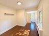Wood-finish flooring, white trim, recessed lighting, white panel door, and window with natural light, door to a full bathroom.