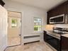 Rich wood-finish cabinetry, new stainless steel appliances, and wood-finish flooring