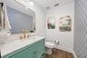 Vanity with a marble-finish countertop, undermount sink, and brass-finish faucet