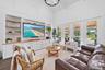 Vaulted ceiling, built-in entertainment center with wood-finish countertops, wall paneling, and multiple glass French doors leading to a covered patio