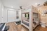 Room featuring wood-finish flooring, white walls, and a ceiling fan