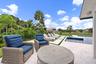 Expansive outdoor living area featuring a pool with water features, a spacious patio, and a manicured lawn