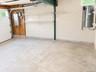 Concrete floor, utility shelving, exposed wood framing, white block walls, overhead lighting