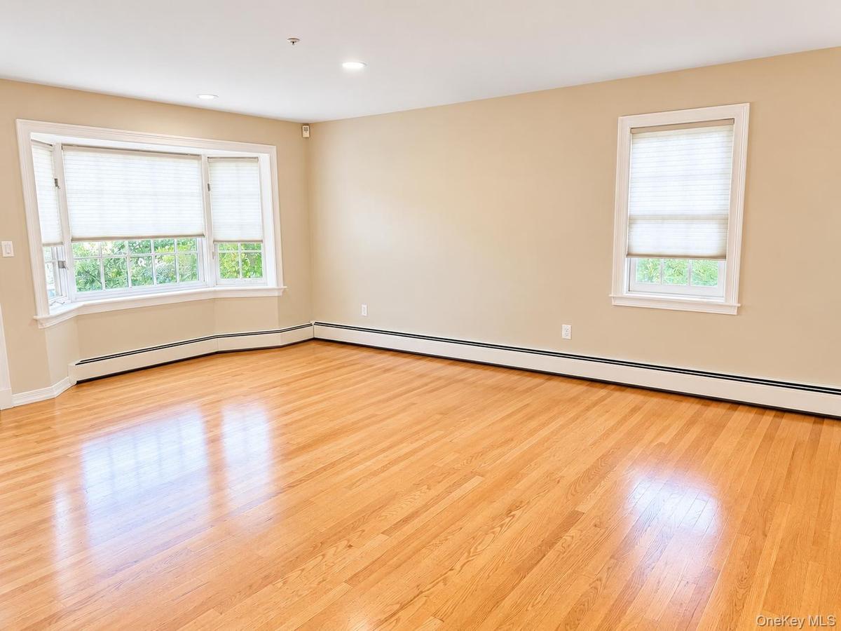 Bay window, hardwood flooring, recessed lighting, and neutral wall tones
