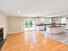 Family room with open Kitchen with white cabinetry, dark countertops, and a central island