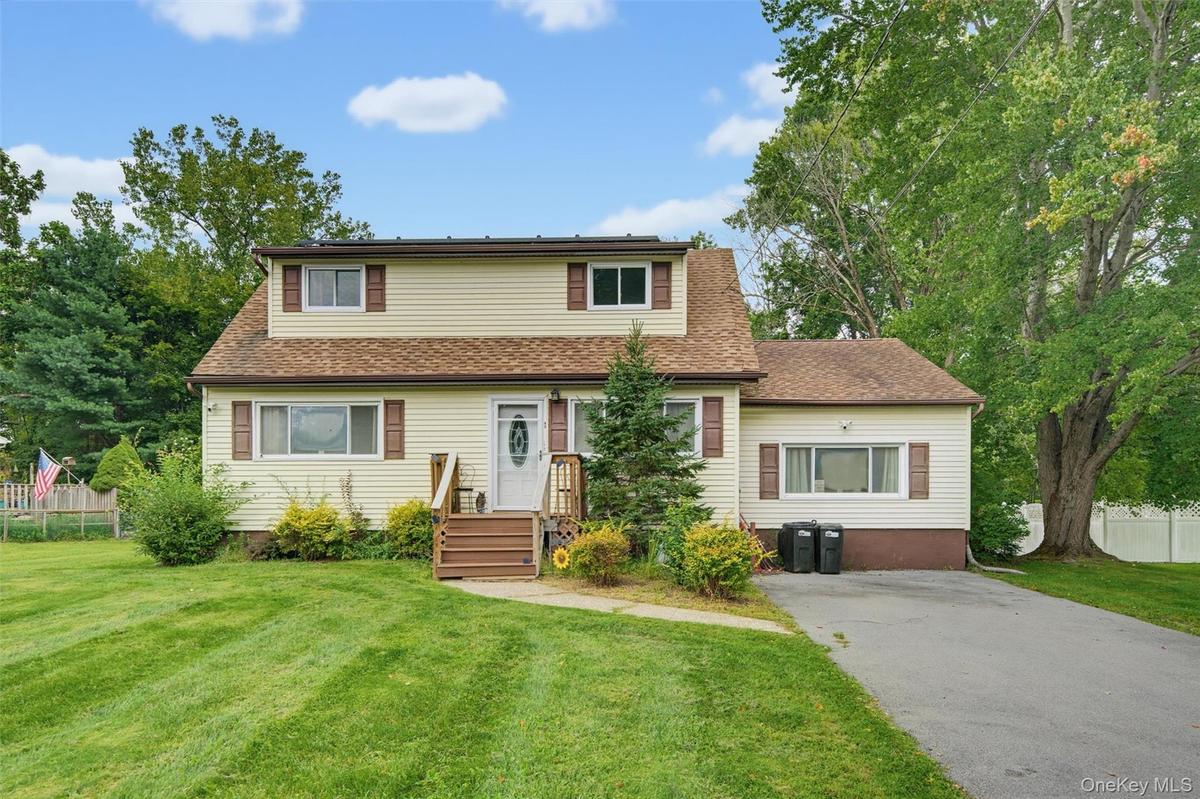 Two-story residence with light-colored siding and brown window shutters