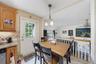 Dining area featuring wood-finish cabinetry, granite-style countertops, and a tiled backsplash