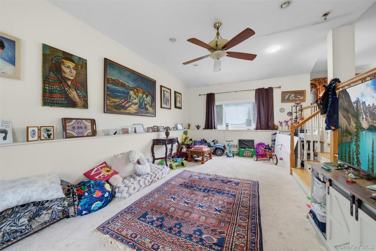 Carpeted living area featuring a ceiling fan with integrated lighting, recessed lighting