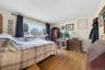 Wood-finish flooring with a large window featuring dark curtains