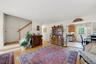 Hardwood flooring, painted white walls, and a wood staircase with white balusters